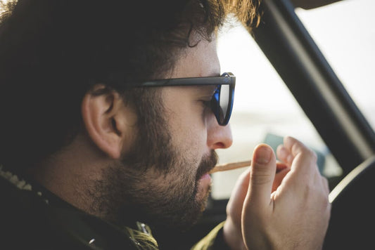 man steekt joint op in de auto